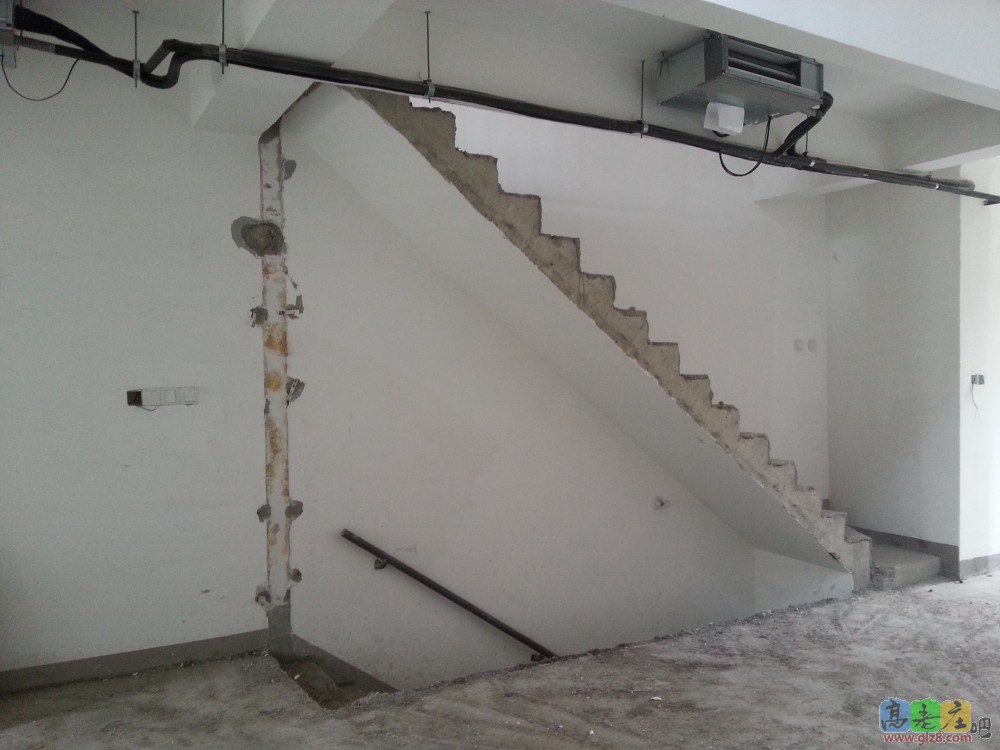 客厅通往二楼和地下室之间的楼梯本来有一堵墙，为了显得通透打掉了